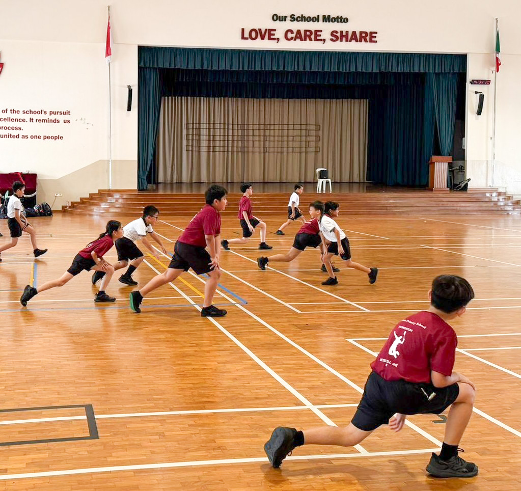 Students performing a series of dynamic warm-up activities to activate their muscles
